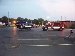 A police car and fire truck in an empty parking lot.