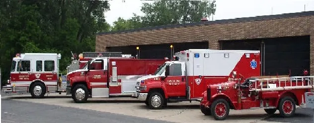 A fire truck and ambulance parked in front of a building.